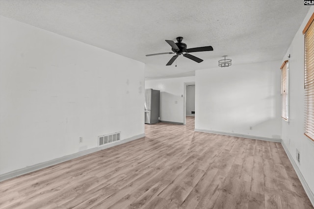 unfurnished living room with a textured ceiling, light hardwood / wood-style floors, and ceiling fan