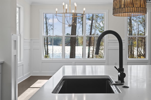 interior details featuring a notable chandelier, ornamental molding, and sink