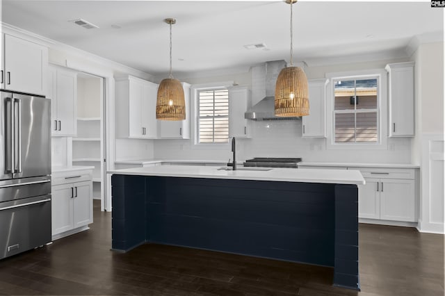 kitchen with pendant lighting, wall chimney exhaust hood, white cabinetry, and high quality fridge