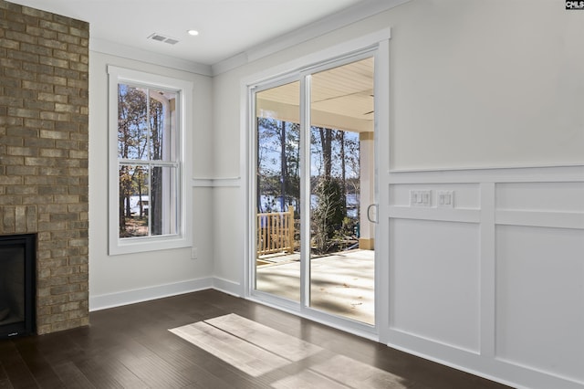 entryway featuring a fireplace, dark hardwood / wood-style floors, and plenty of natural light