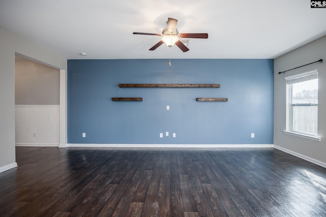 empty room with ceiling fan and dark hardwood / wood-style flooring