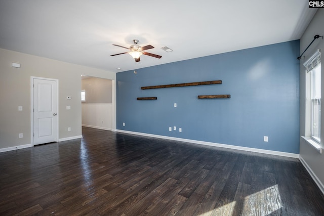 unfurnished living room featuring ceiling fan and dark hardwood / wood-style flooring