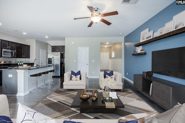 living room featuring ceiling fan and sink