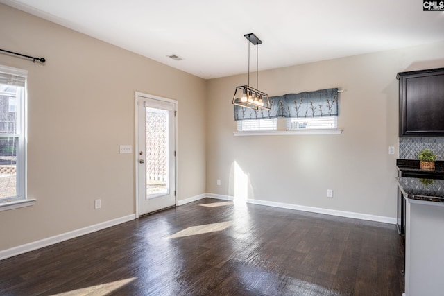 unfurnished dining area with a healthy amount of sunlight and dark hardwood / wood-style flooring