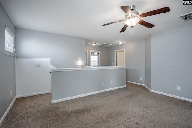 carpeted empty room with ceiling fan and a healthy amount of sunlight