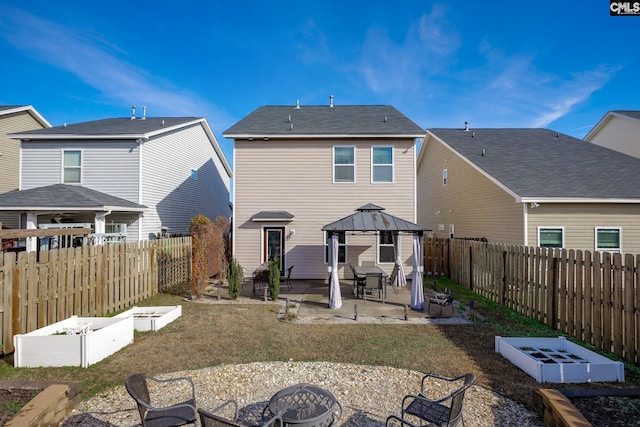 back of property featuring a gazebo, an outdoor fire pit, a patio area, and a lawn