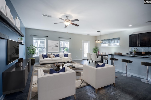 living room with ceiling fan, plenty of natural light, and sink