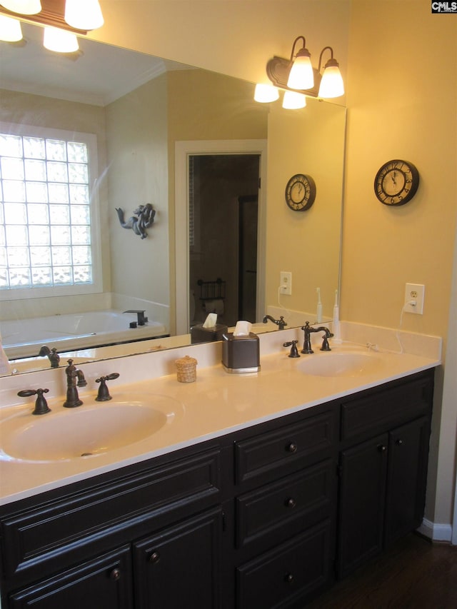 bathroom featuring vanity, ornamental molding, and a tub