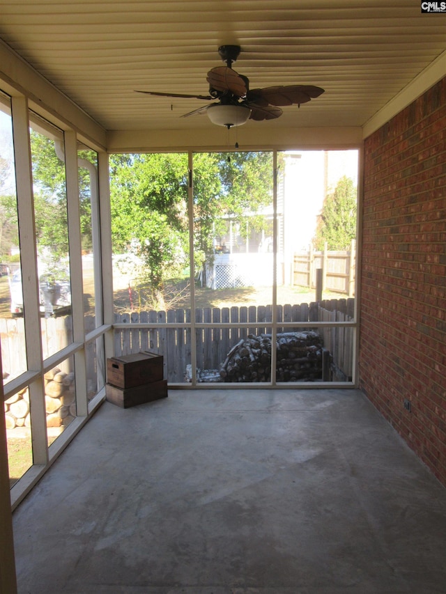 unfurnished sunroom with ceiling fan