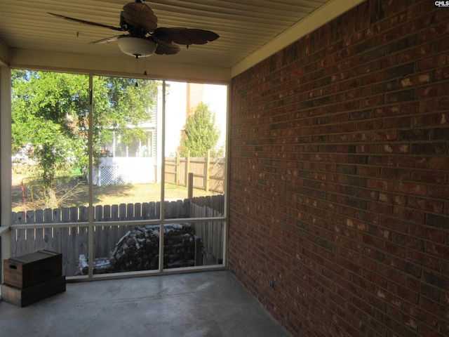 unfurnished sunroom with ceiling fan