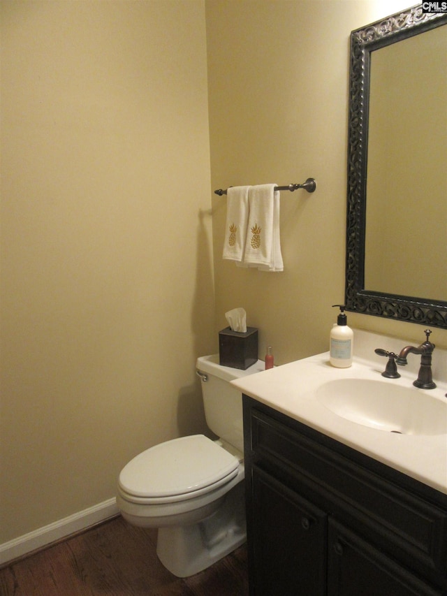 bathroom with wood-type flooring, vanity, and toilet