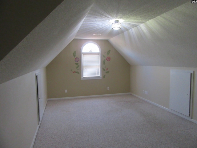 bonus room with light carpet and vaulted ceiling