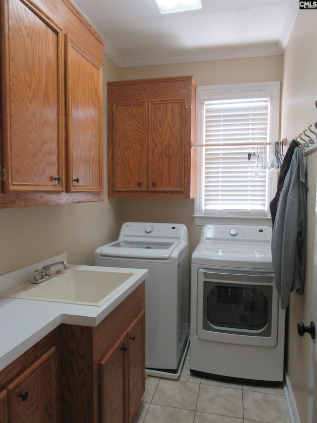 washroom featuring cabinets, ornamental molding, washer and clothes dryer, sink, and light tile patterned floors