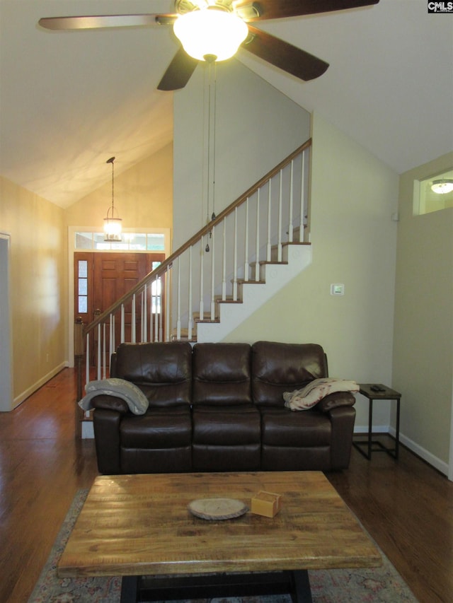 living room with ceiling fan with notable chandelier, dark hardwood / wood-style flooring, and vaulted ceiling