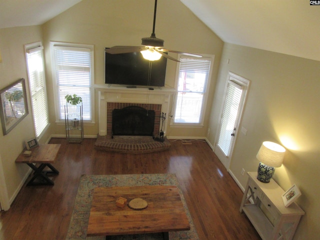 living room featuring ceiling fan, dark wood-type flooring, lofted ceiling, and a brick fireplace