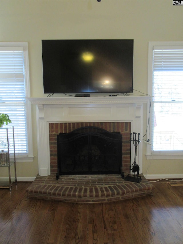 interior details with wood-type flooring and a brick fireplace