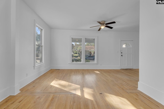 unfurnished living room with ceiling fan, a healthy amount of sunlight, and light wood-type flooring