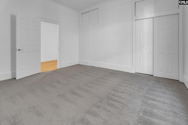 unfurnished bedroom with a closet, carpet, and ornamental molding