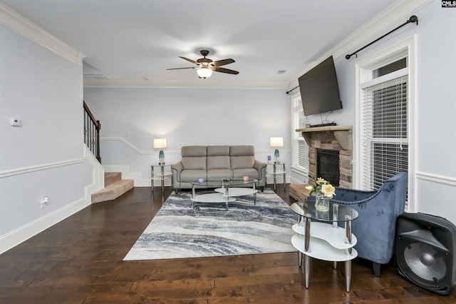 living room featuring crown molding, a fireplace, ceiling fan, and dark hardwood / wood-style floors