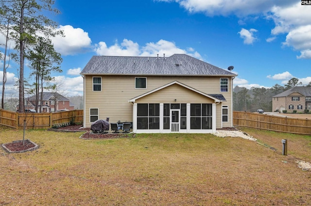 rear view of house with a sunroom and a yard