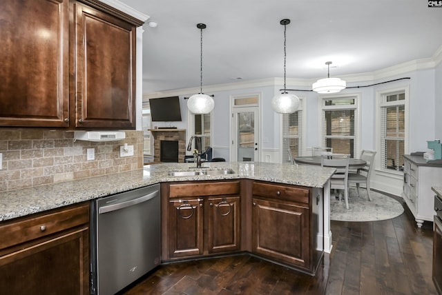 kitchen featuring stainless steel dishwasher, dark brown cabinets, sink, and hanging light fixtures