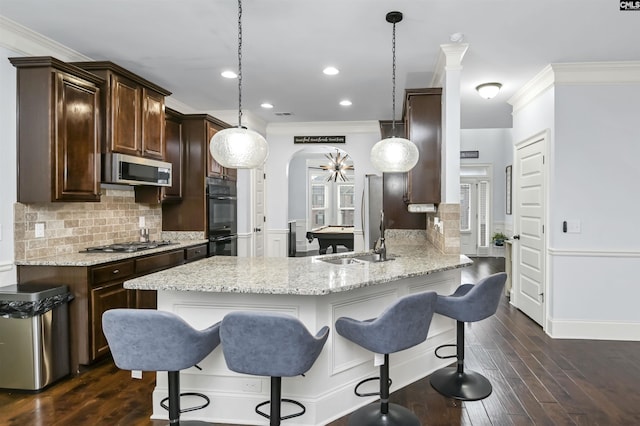 kitchen featuring dark wood-type flooring, stainless steel appliances, kitchen peninsula, decorative light fixtures, and pool table