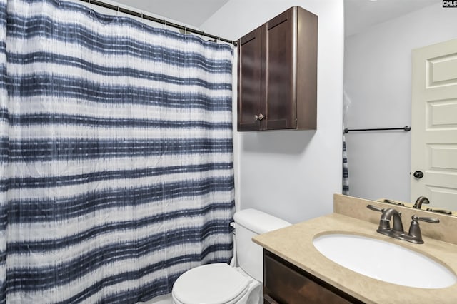 bathroom featuring vanity, toilet, and walk in shower