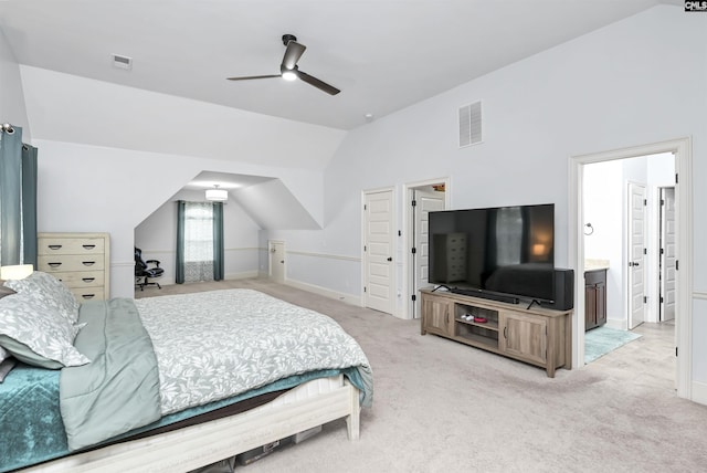 carpeted bedroom featuring ensuite bathroom, ceiling fan, and vaulted ceiling