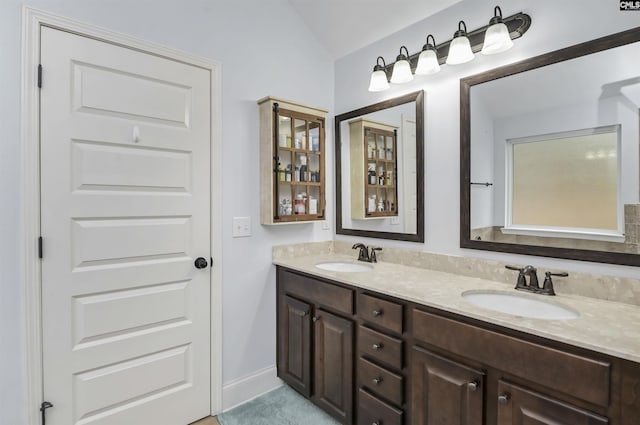 bathroom with vanity and lofted ceiling