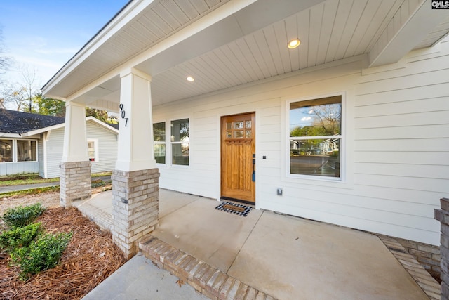 view of exterior entry featuring covered porch