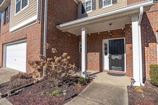 doorway to property with covered porch and a garage