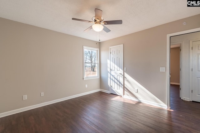 spare room featuring a textured ceiling, ceiling fan, and dark wood-type flooring