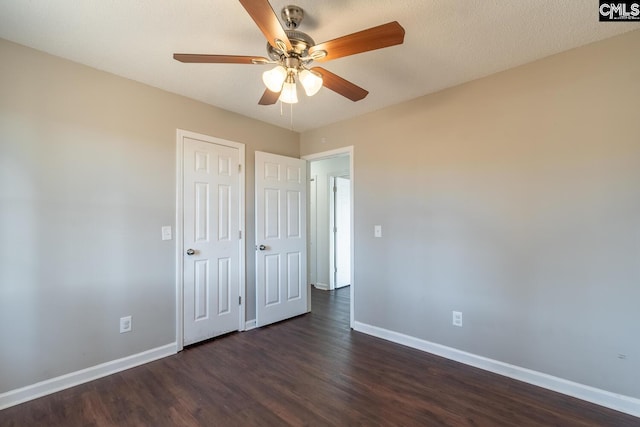 unfurnished bedroom with ceiling fan and dark hardwood / wood-style floors