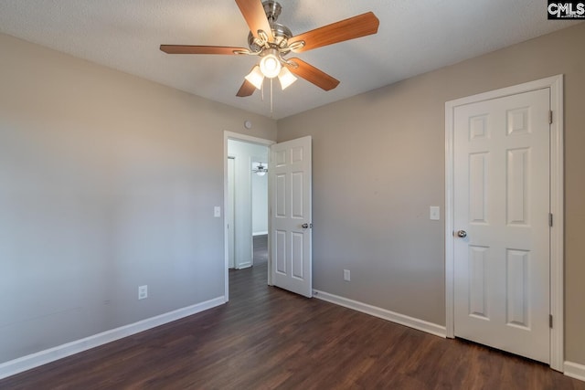 unfurnished bedroom featuring a textured ceiling, ceiling fan, and dark wood-type flooring