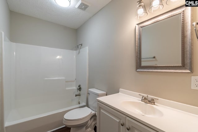 full bathroom with vanity, tub / shower combination, toilet, and a textured ceiling