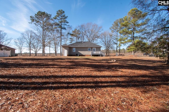 view of yard with a rural view and a wooden deck