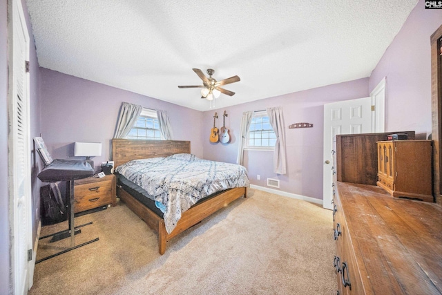 bedroom featuring multiple windows, ceiling fan, and light colored carpet