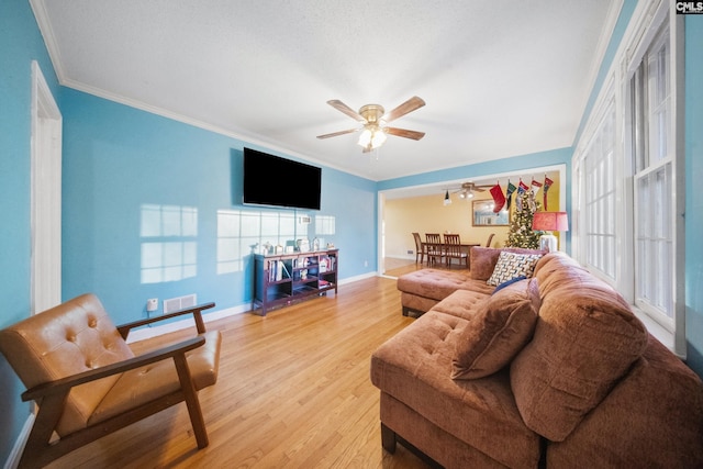 living room with wood-type flooring, ceiling fan, and ornamental molding