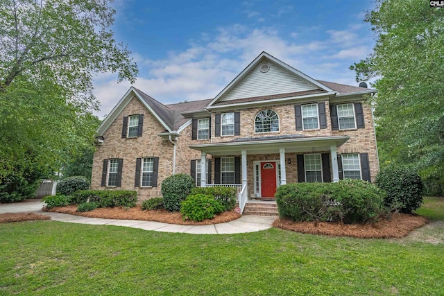 colonial home with a front yard and covered porch