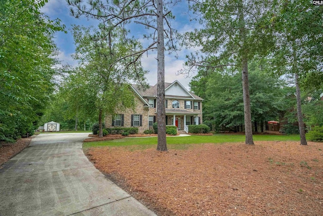 view of front of house featuring a front yard and a storage unit