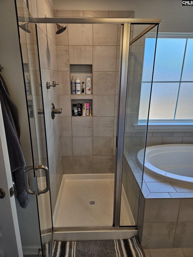 bathroom with a stall shower and a bath