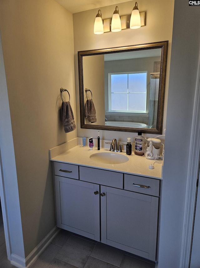 full bath featuring tile patterned floors, vanity, baseboards, and a shower with door