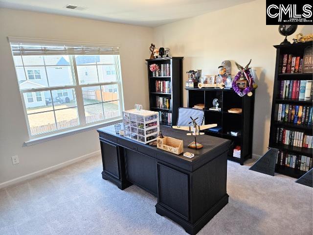 office space featuring baseboards, light carpet, and visible vents