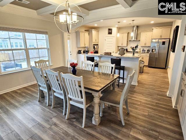 dining area with beamed ceiling, dark wood-style floors, coffered ceiling, and a chandelier