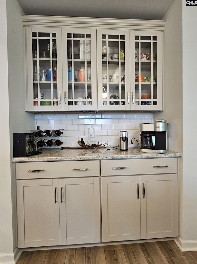 bar with baseboards, tasteful backsplash, and wood finished floors