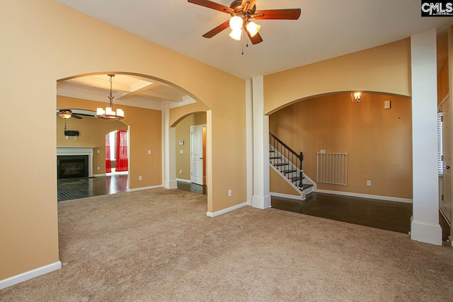 unfurnished living room with carpet flooring, beam ceiling, ceiling fan with notable chandelier, and coffered ceiling