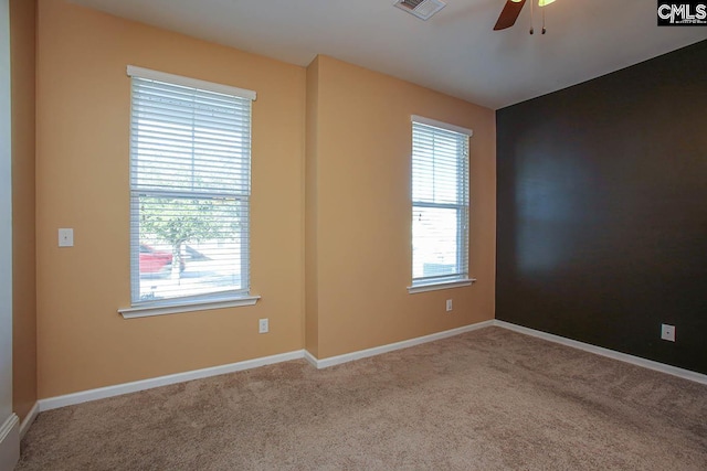 spare room featuring light carpet and ceiling fan