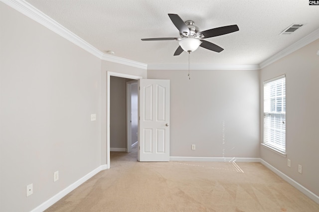 carpeted empty room featuring a textured ceiling, ceiling fan, and crown molding