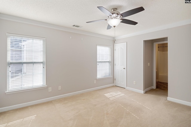 unfurnished bedroom with ceiling fan, light colored carpet, ornamental molding, and multiple windows