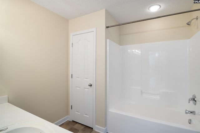 bathroom with shower / tub combination, tile patterned floors, vanity, and a textured ceiling